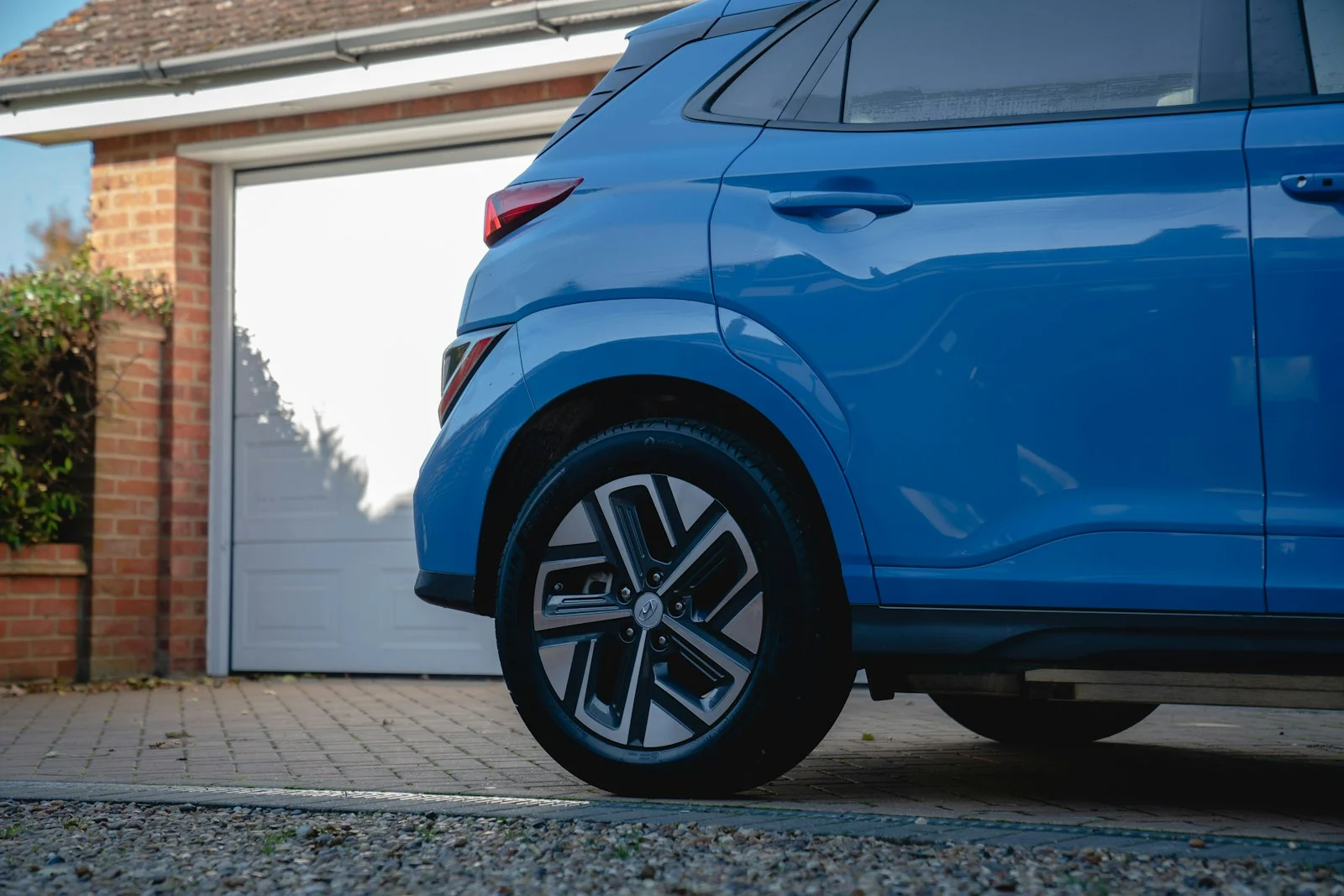 Blue car parked in front of a garage door