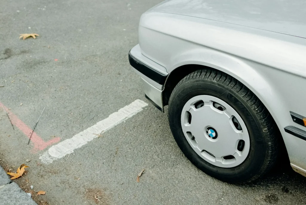 Silver car parked at the kerb, showing its front tyre and wheel trim